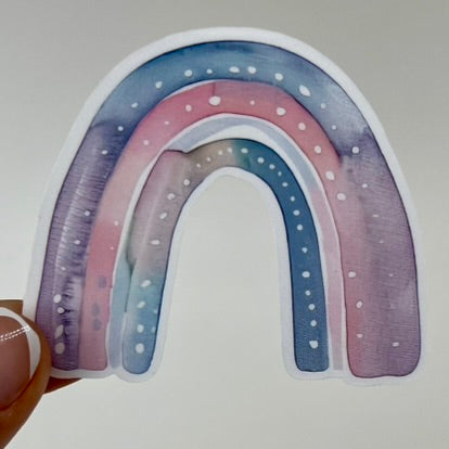 A vinyl sticker with a blue and pink watercolor rainbow design.