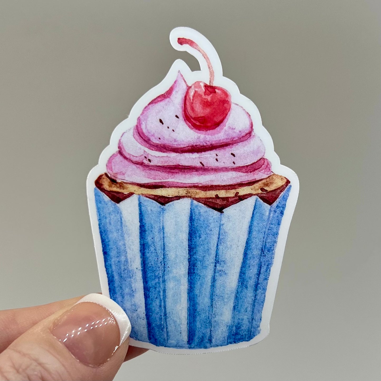 Vinyl sticker of a cherry cupcake with a blue wrapper.