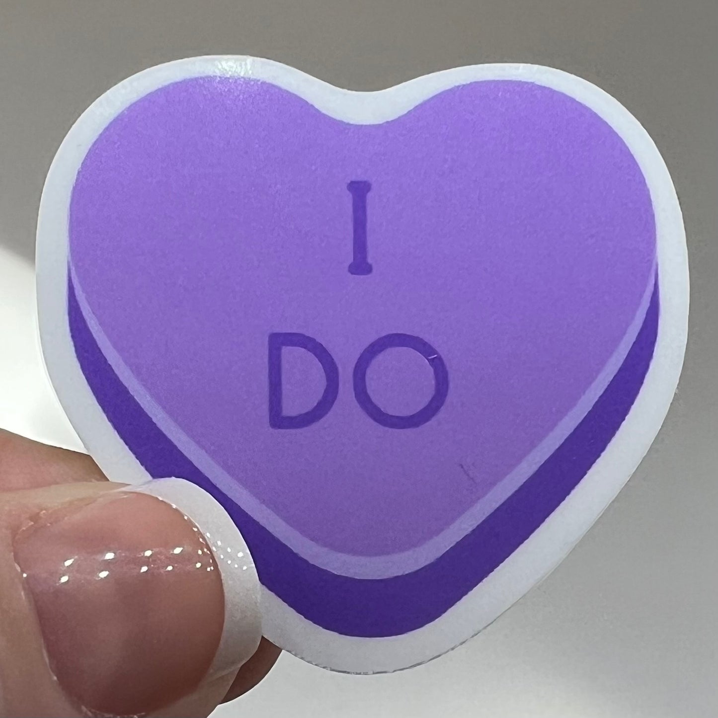 Vinyl sticker of a purple conversation heart which says "I DO".