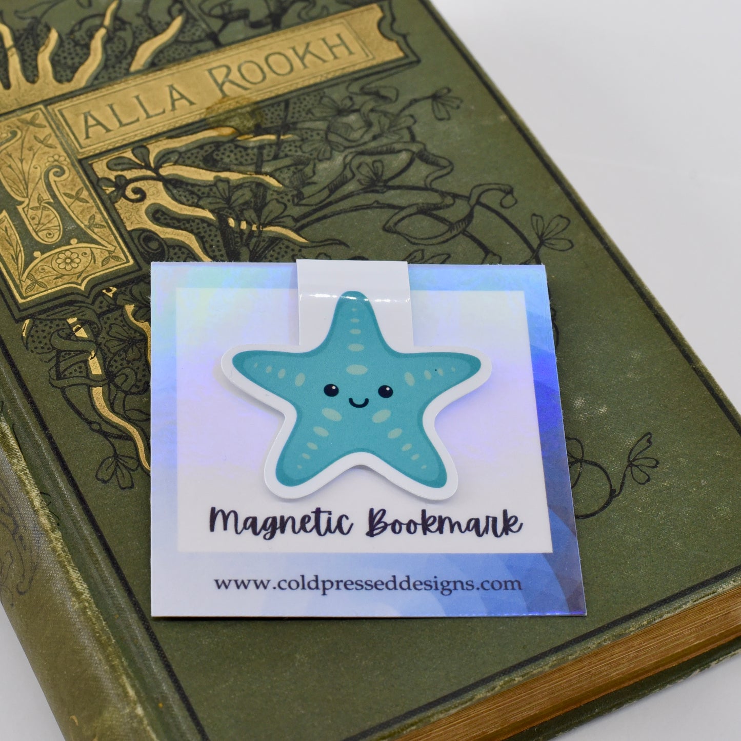 A glossy, magnetic bookmark shaped like a teal blue starfish with a happy kawaii face.