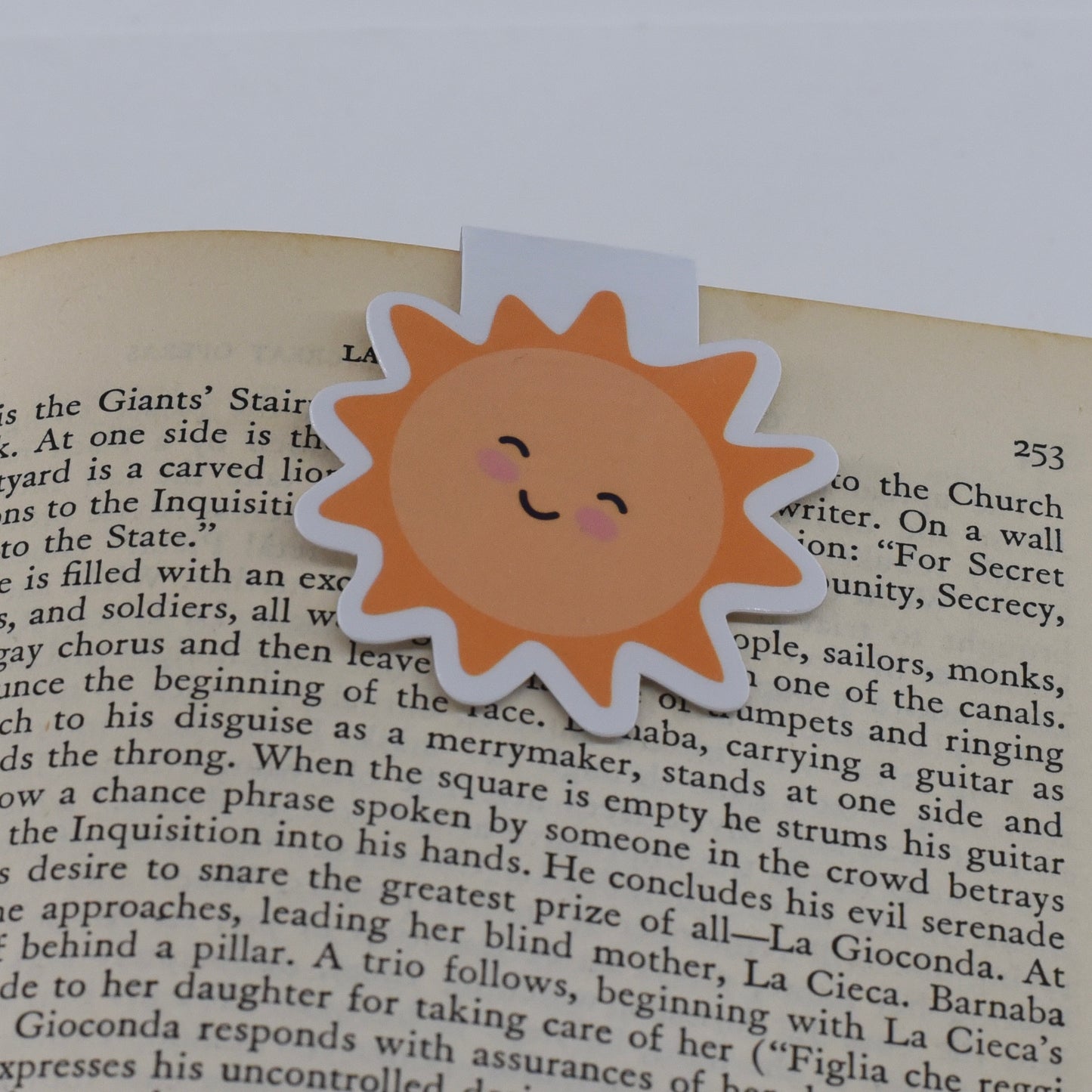 A glossy, double-sided magnetic bookmark in a yellow sun design with a kawaii face.