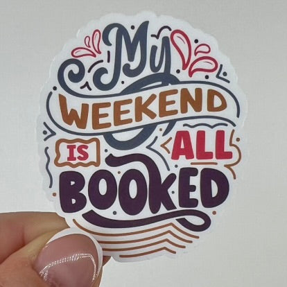 A vinyl sticker with the phrase 'My weekend is all booked' in various colors.