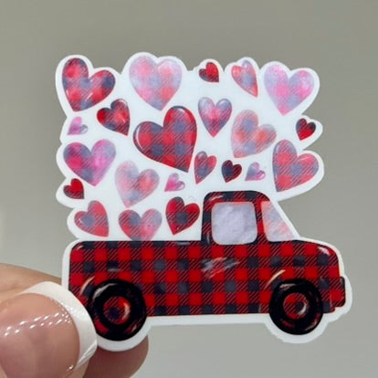 A vinyl sticker of a red pickup truck with a plaid pattern and hearts design.