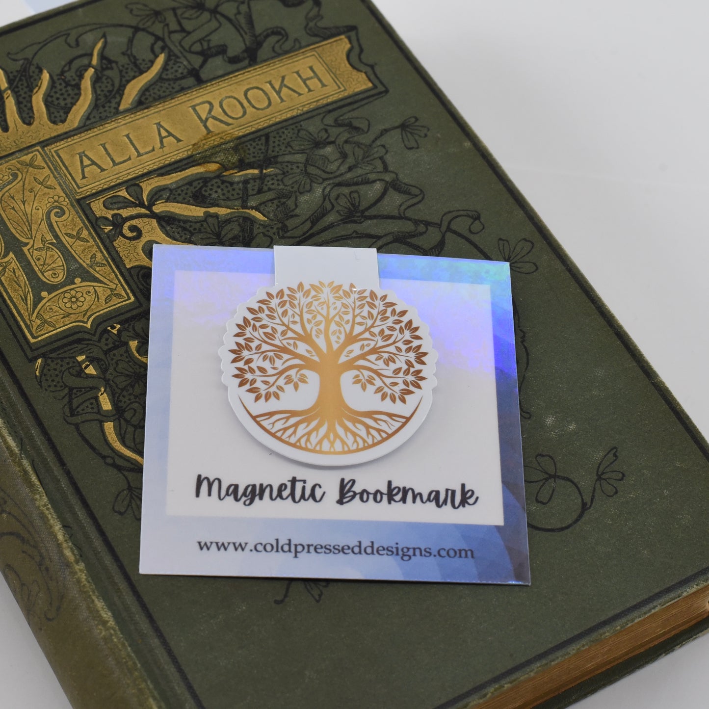 A round, glossy magnetic bookmark with a gold tree of life design.