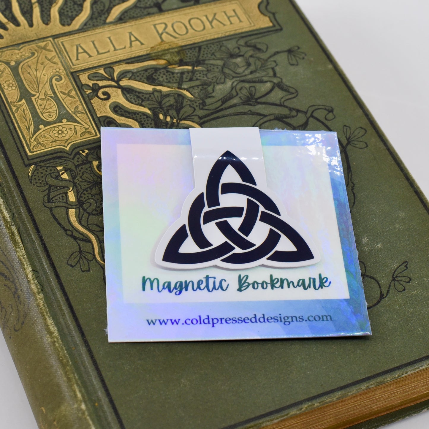 A glossy, double-sided magnetic bookmark with a black triquetra symbol design.