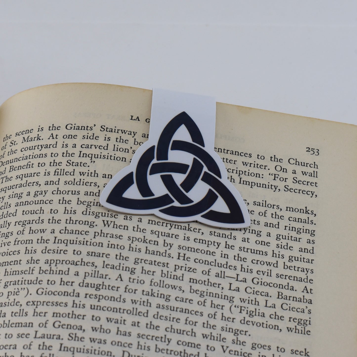 A glossy, double-sided magnetic bookmark with a black triquetra symbol design.