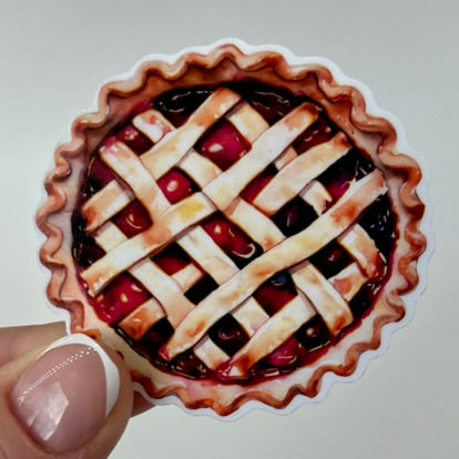 A vinyl sticker in the shape of a baked cherry pie with a lattice style crust on top.