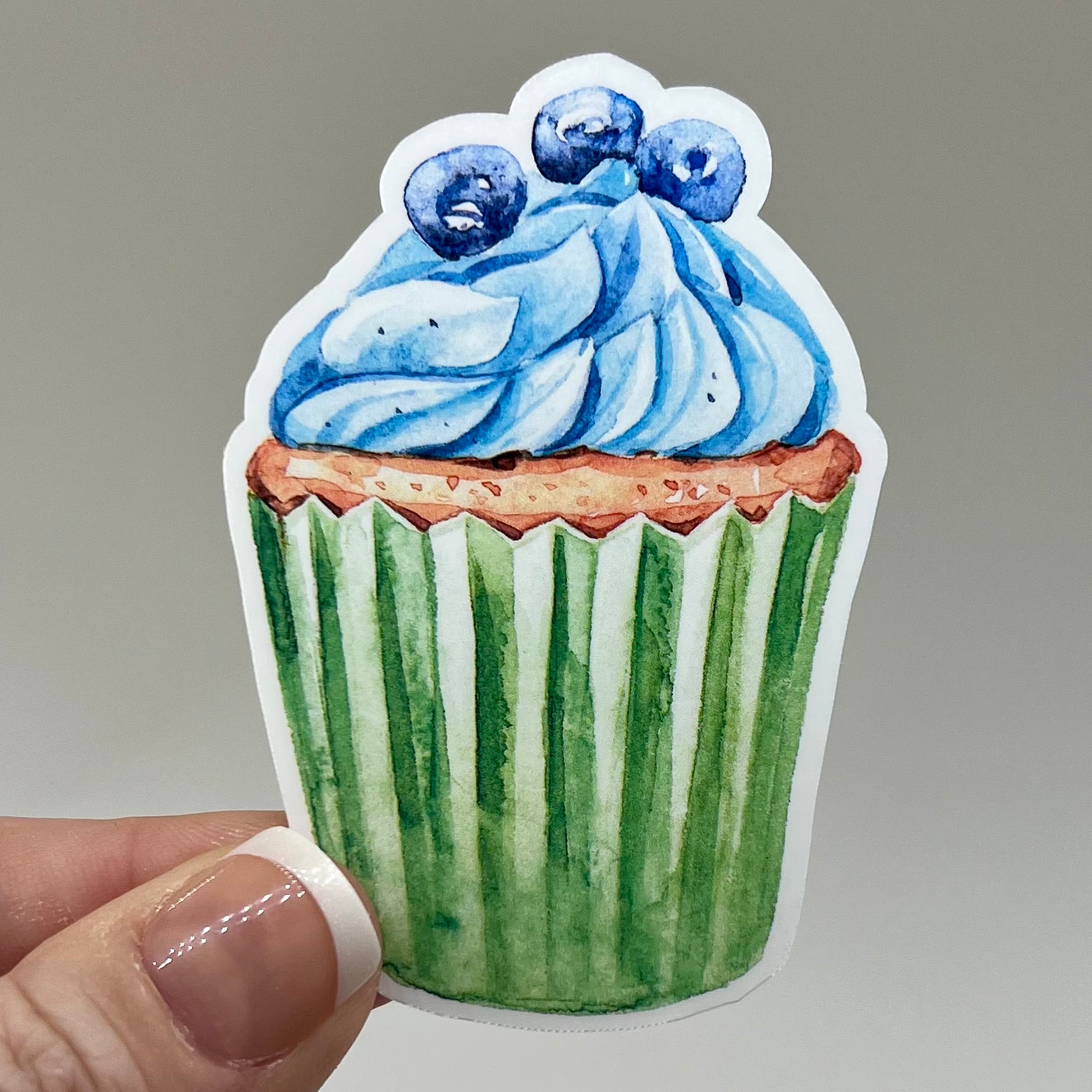 Vinyl sticker of a blueberry cupcake sticker with a green wrapper.