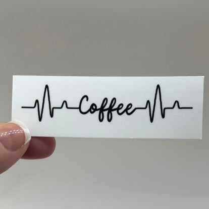 A vinyl sticker with the word 'Coffee' written in a stylized font resembling a EKG line.