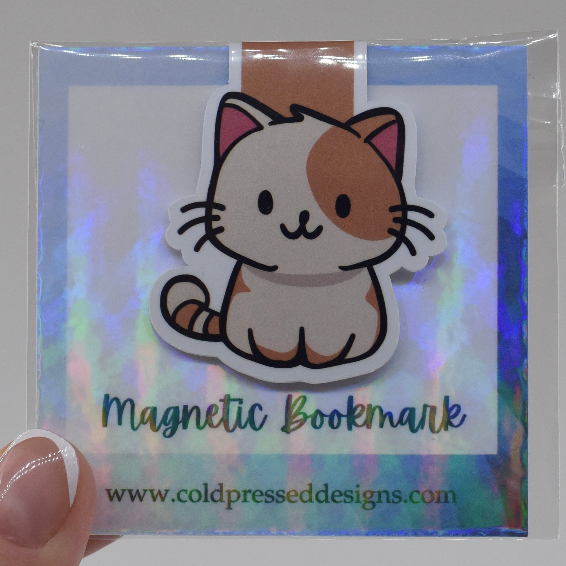 A handmade magnetic bookmark featuring a cartoon image of a happy cat on a glossy background, packaged in a clear plastic sleeve with a reflective surface.