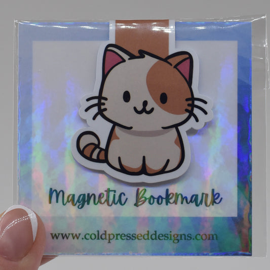 A handmade magnetic bookmark featuring a cartoon image of a happy cat on a glossy background, packaged in a clear plastic sleeve with a reflective surface.