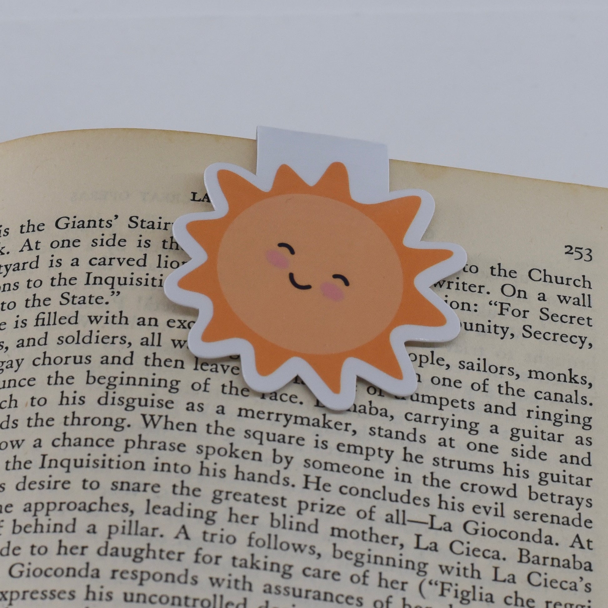 A glossy, double-sided magnetic bookmark in a yellow sun design with a kawaii face.