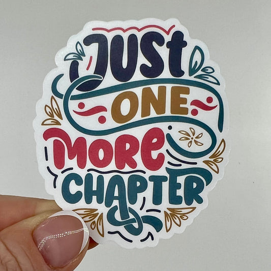 A vinyl sticker with the text 'Just One More Chapter' and decorative elements in various colors.