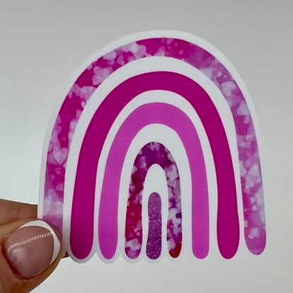 A vinyl sticker of a rainbow with pink bands.