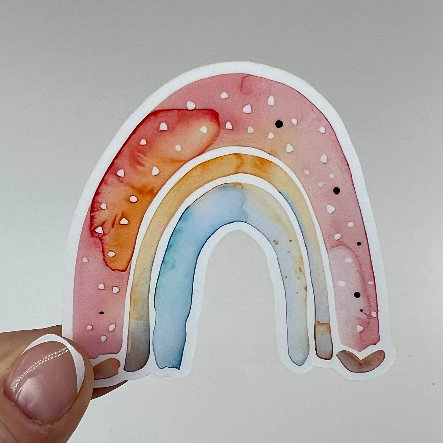 A vinyl sticker with watercolor arches in red, yellow and blue.
