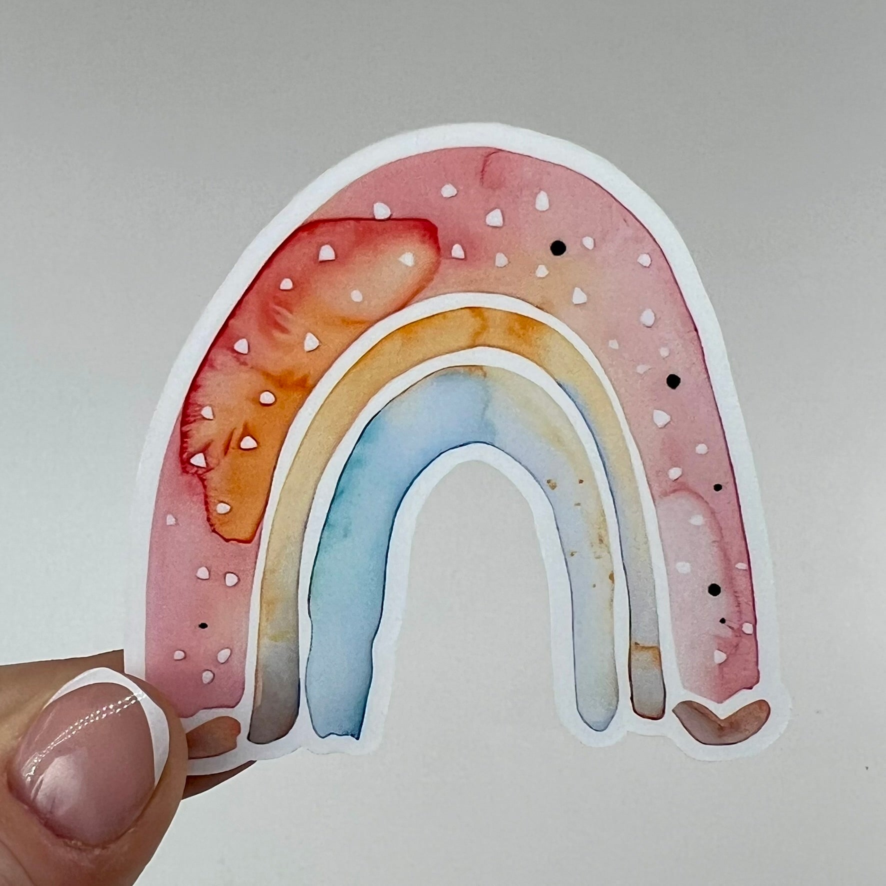 A vinyl sticker with watercolor arches in red, yellow and blue.
