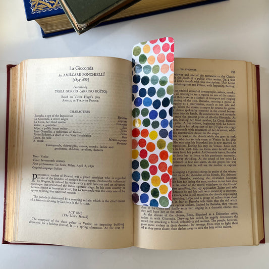A glossy rectangular bookmark with watercolor dots in a rainbow of colors.