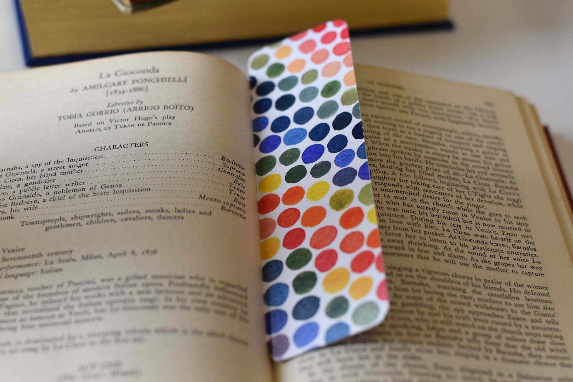A glossy rectangular bookmark with watercolor dots in a rainbow of colors.