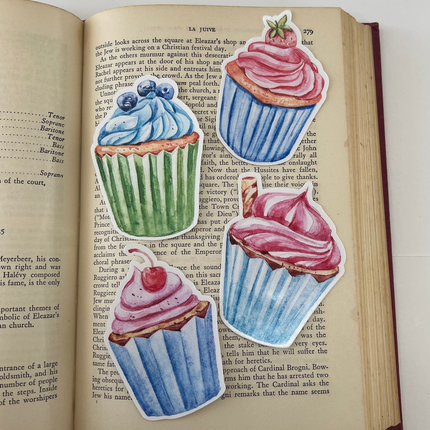Four vinyl stickers with illustrations of cupcakes in blue, pink, and green colors, garnished with blueberries, strawberry, cherry and pirouette.