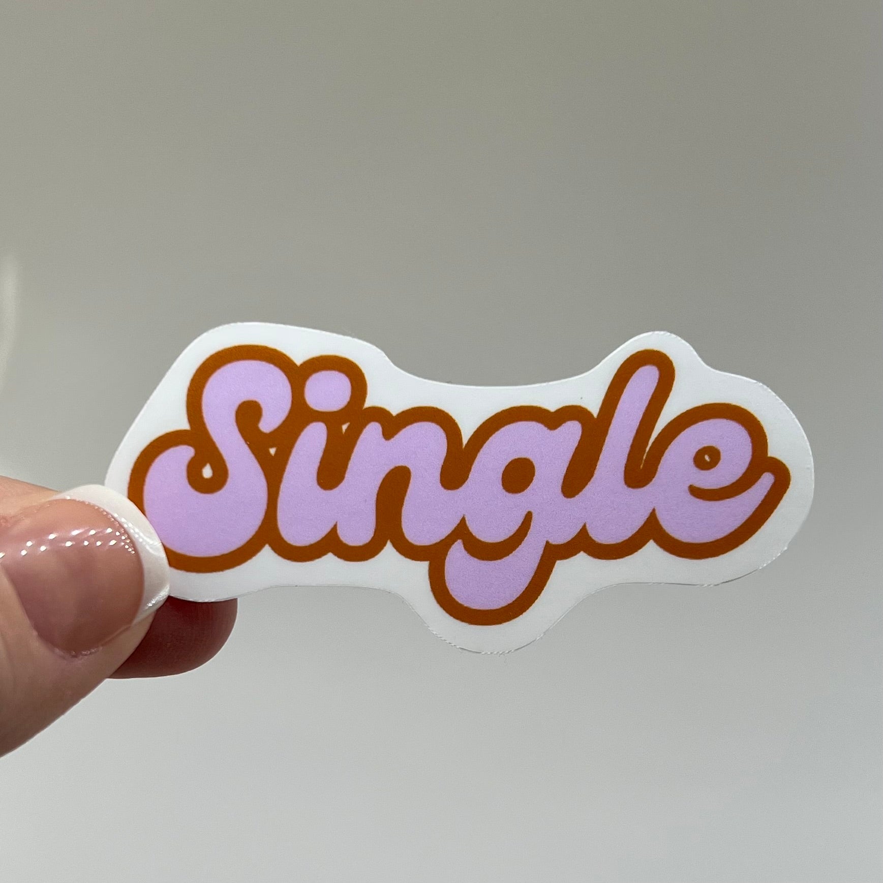 A vinyl sticker with the word 'Single' written in a pink cursive script with a border.