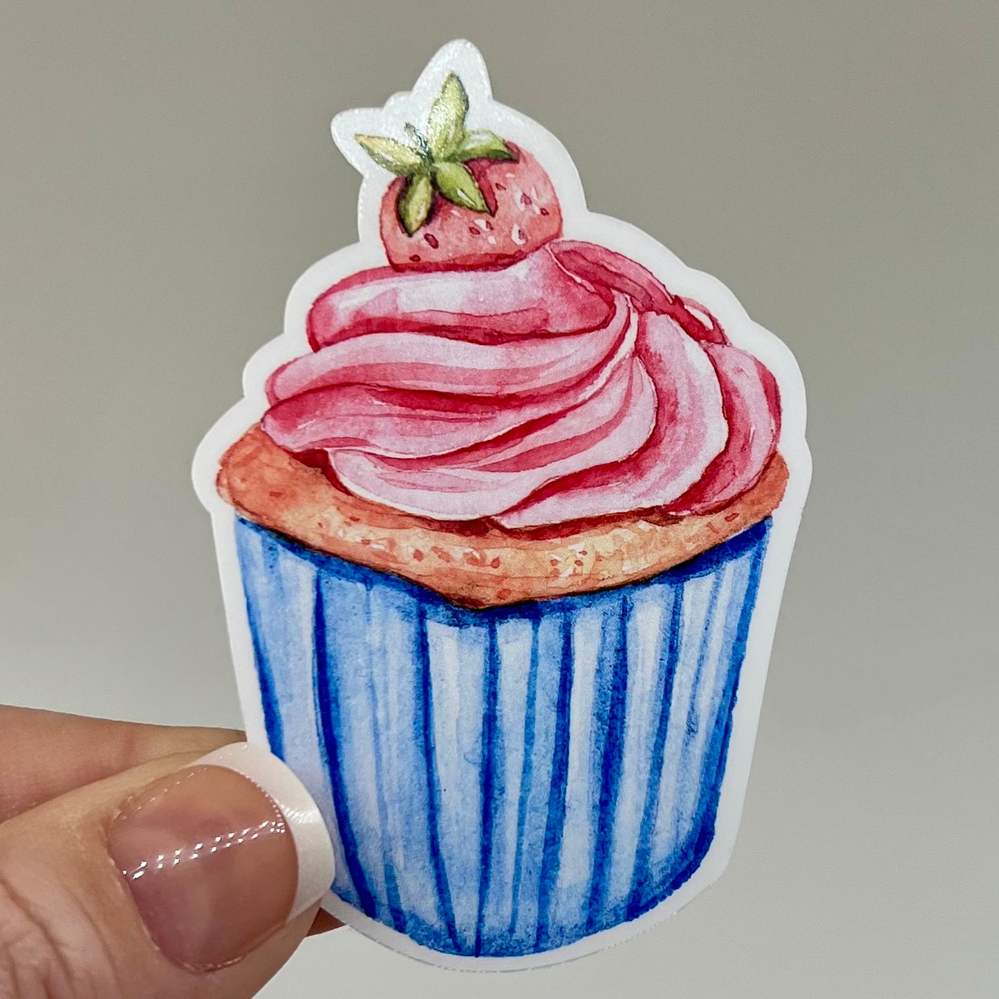 Vinyl sticker of a strawberry cupcake with a blue wrapper.